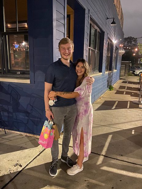 Vanessa Borjon, right, with current partner Michael Bayler holding each other on the sidewalk and smiling