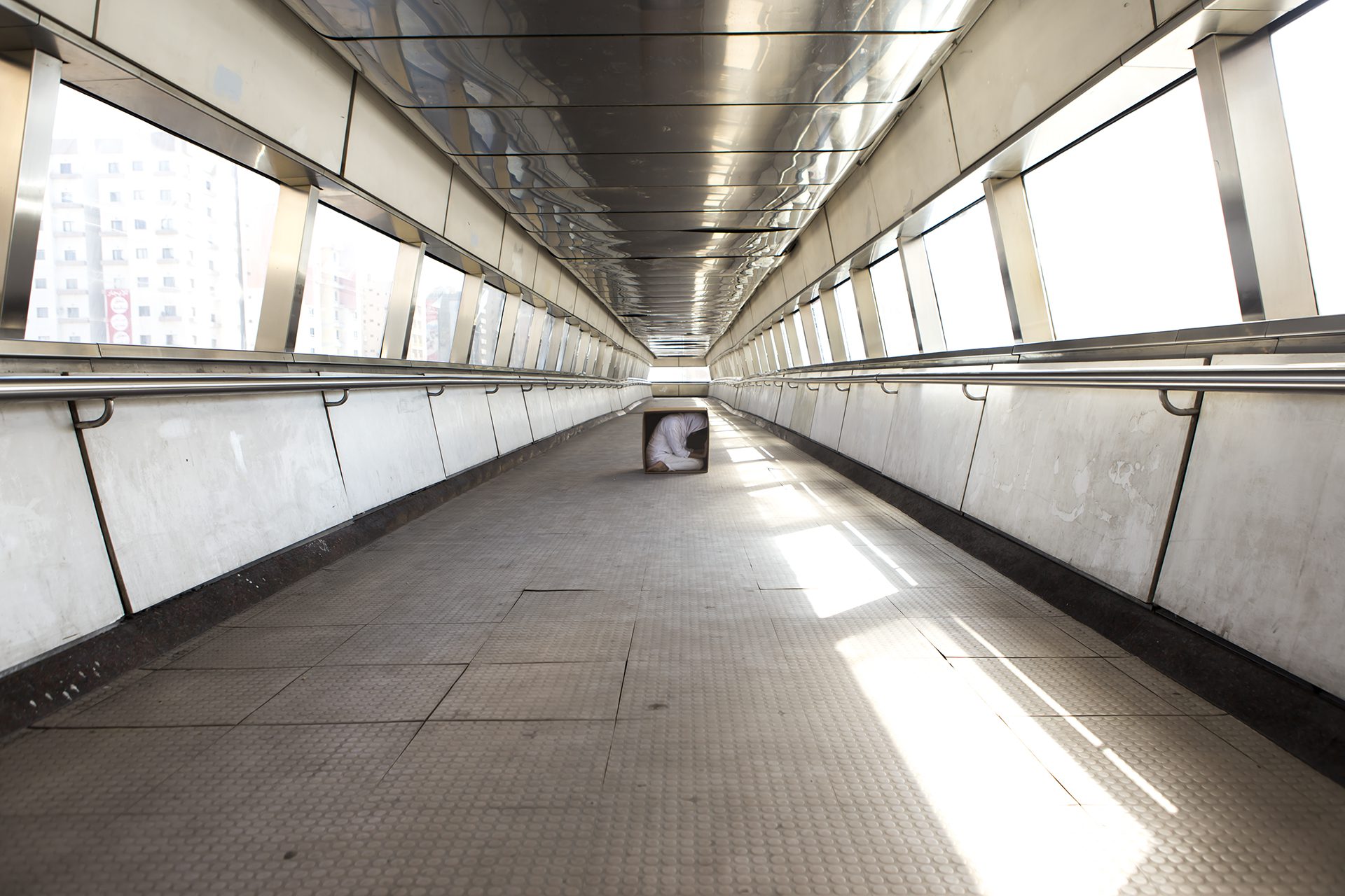 W woman in a box at the end of an enclosed walkway