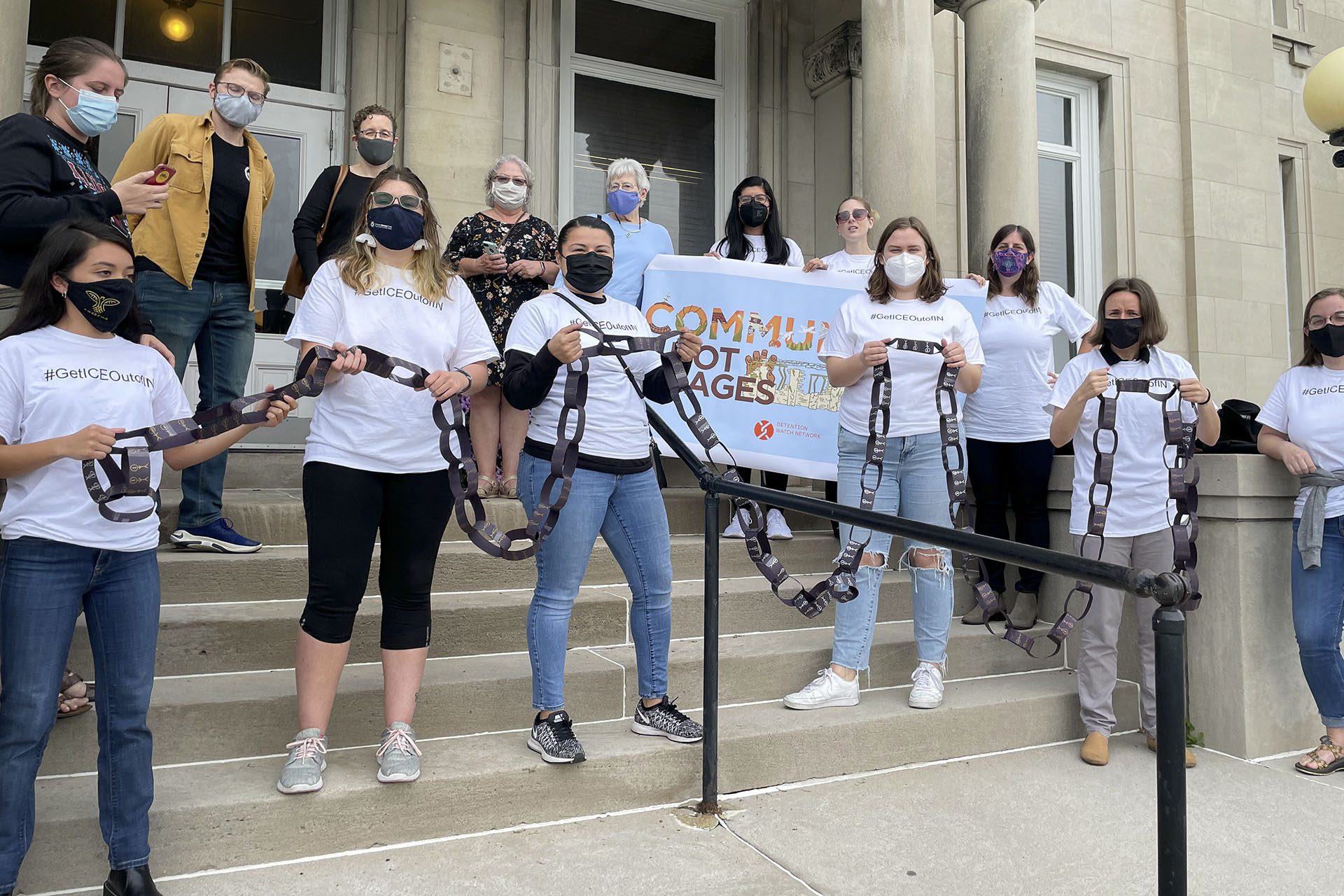 Members of the Communities Not Cages Indiana Coalition in front of the Clay County Courthouse breaking a symbolic chain