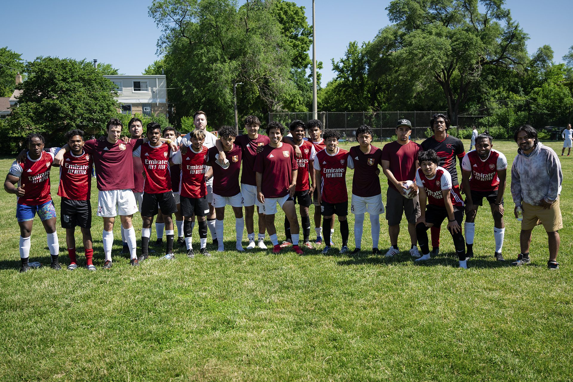 group of soccer players on a field; most wearing red jerseys