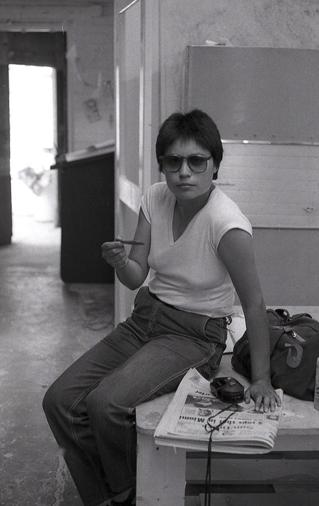 archival photo of Diana with a camera, camera bag, and newspaper