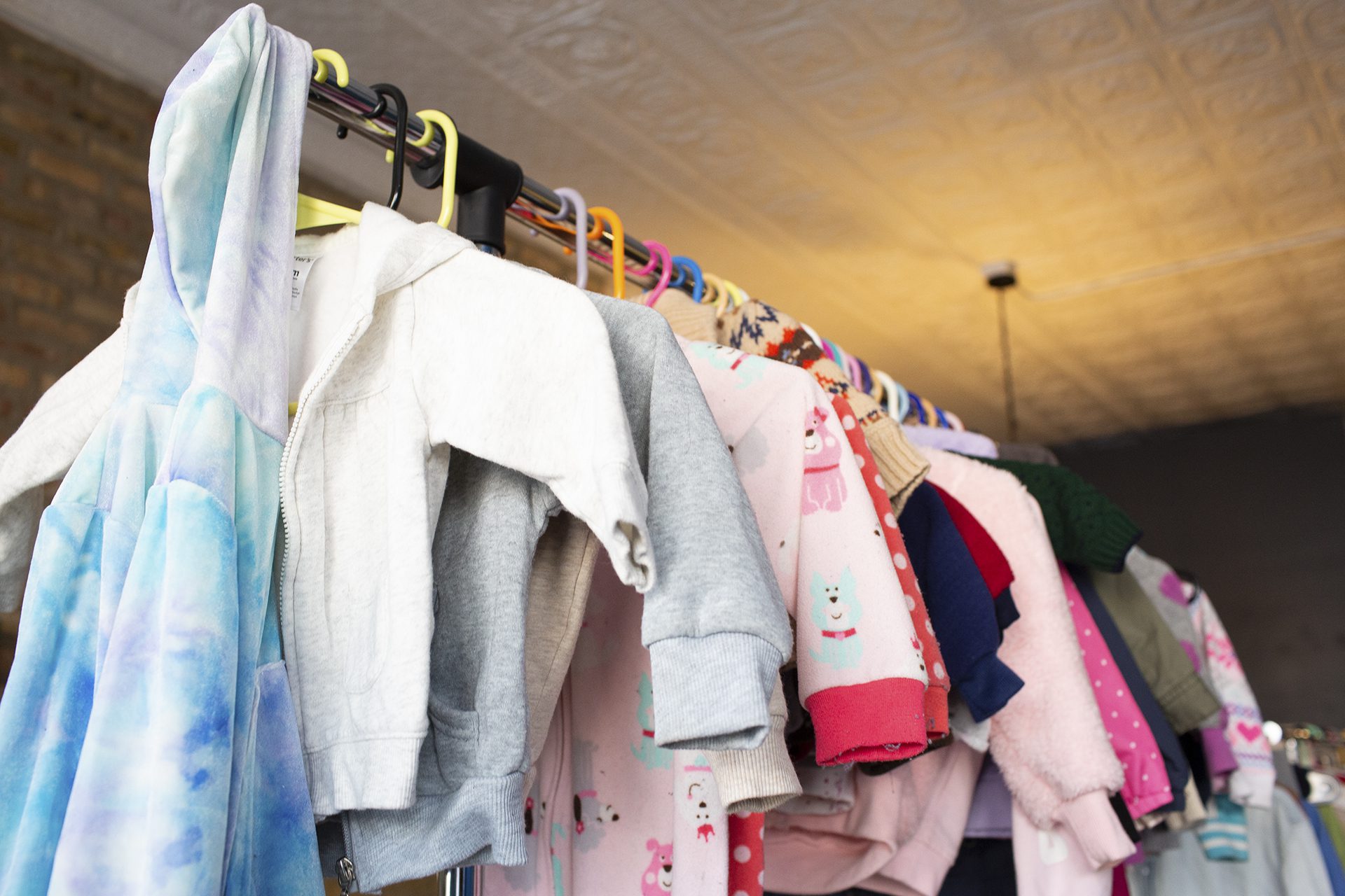 coats over various colors hang on a rack