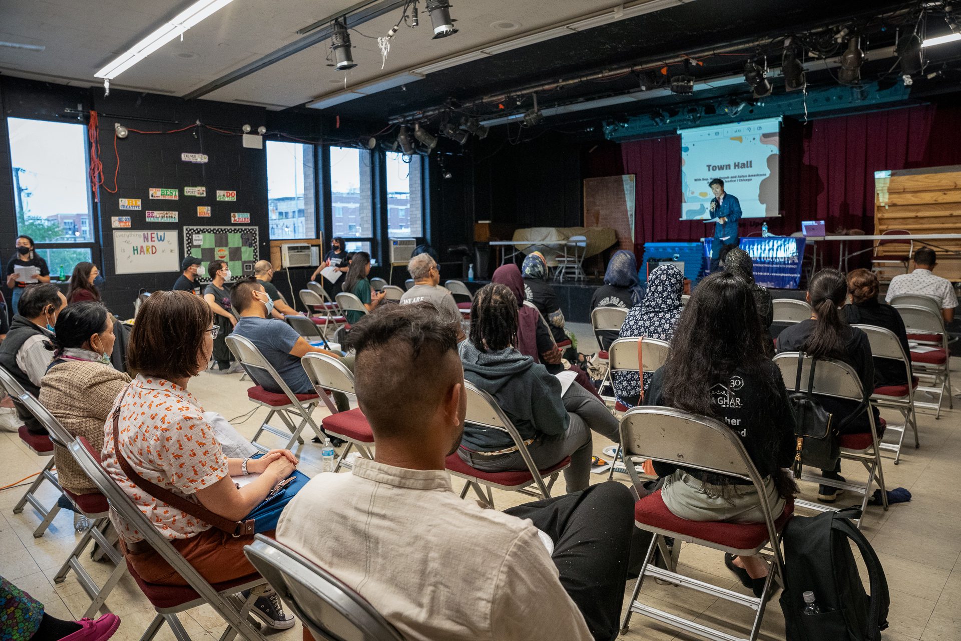 State Rep. Hoan Huynh stands before rows of people to discuss a language access bill at a recent town hall in Chicago.