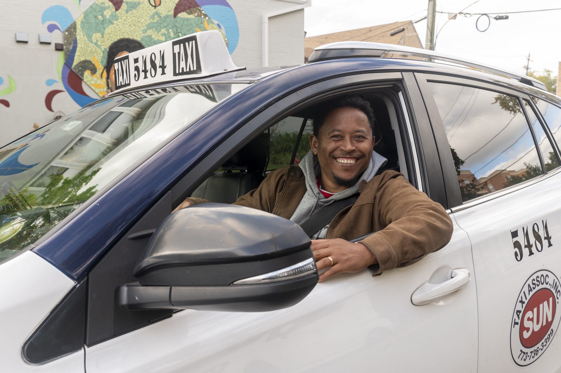 A man sits in his recently purchased taxi cab on Chicago's Northwest Side.